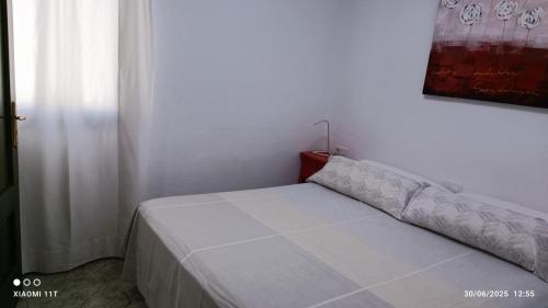 a bed in a white room with at ÁTICO EN PRIMERA LINEA DE PLAYA in Gran Tarajal