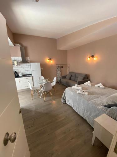a bedroom with a bed and a table and a couch at Apartamentos Basílica Santa Eulalia con Parking Gratis in Mérida