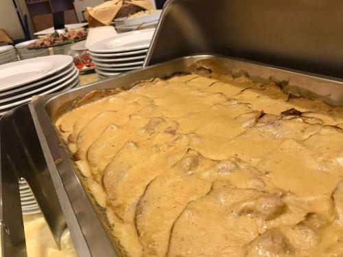 a cake in a pan in a table with plates at Park Hotel Villa Americana in Rodi Garganico