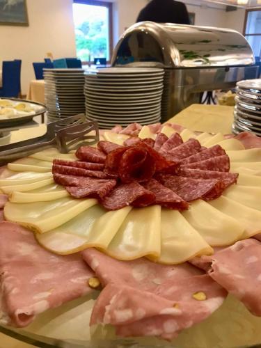 a plate of bacon and cheese on a table at Park Hotel Villa Americana in Rodi Garganico