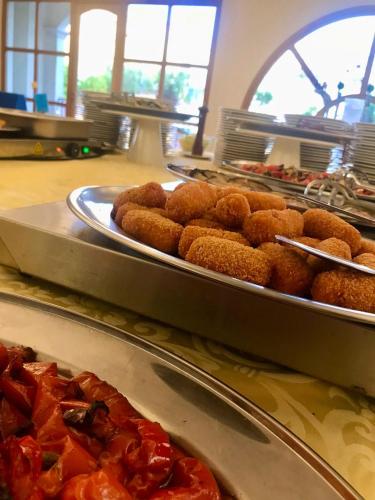 a buffet line with two trays of food with pizza at Park Hotel Villa Americana in Rodi Garganico