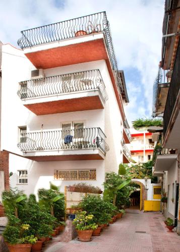 a white building with balconies and potted plants at Hotel da Peppe in Letojanni