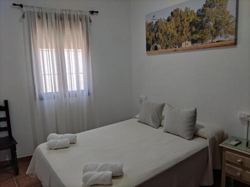 a bedroom with a bed with two towels on it at Alojamiento Rural El Sombrero in El Rocío