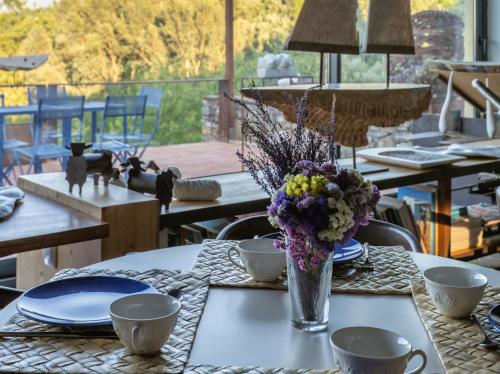 a table with a vase of flowers on it at Quinta do Barrieiro - Art Selection by Maria Leal da Costa in Marvão
