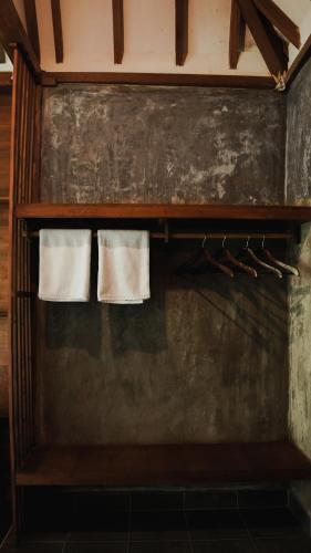 two towels are hanging on a shelf in a bathroom at The Karu Cabin in Penebel