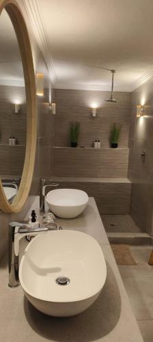a bathroom with a white sink and a mirror at Bambuu Lakeside Lodge in Hazyview