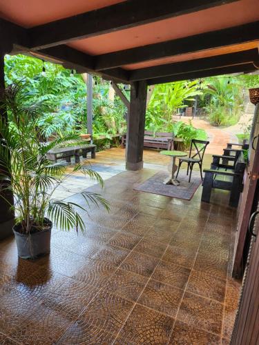 a patio with benches and a table and a plant at Hacienda Siesta Alegre in Rio Grande