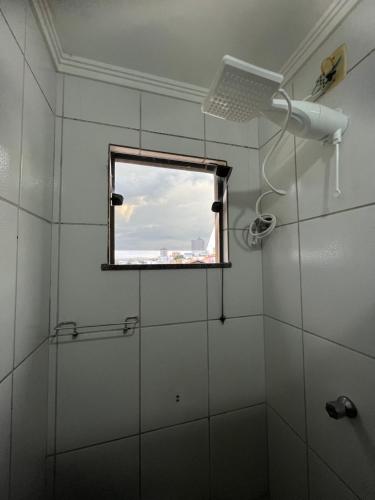 a bathroom with a shower and a window at Apartamento Central em Alfenas in Alfenas