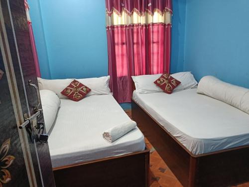 two beds in a room with blue walls and curtains at Hotel Shahin Residential Jatrabari in Dhaka