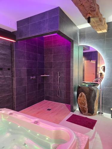 a bathroom with a tub and a shower with purple lighting at Mont Evasion Spa in Tanis