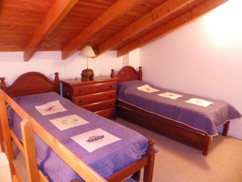 a bedroom with two twin beds and a dresser at Departamento Cerro Catedral in San Carlos de Bariloche