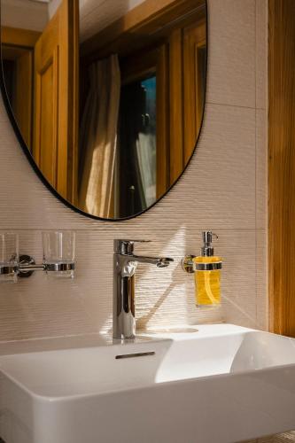 a bathroom sink with a large mirror above it at Hôtel de Commune - Rougemont in Rougemont