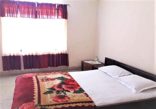 a bedroom with a bed with a blanket on it at Hotel Shahin Residential Jatrabari in Dhaka