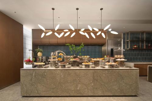 eine Küche mit einer Theke mit Essen darauf in der Unterkunft Hilton Garden Inn Zhongwei Shapotou in Zhongwei