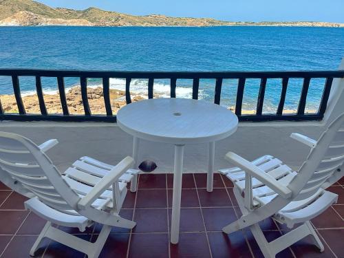 un tavolo e delle sedie su un balcone con vista sull'oceano di P98 - Bonito apartamento sobre el mar a Fornells