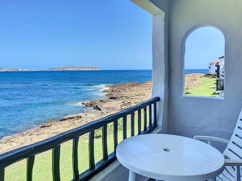un tavolo su un balcone con vista sull'oceano di P98 - Bonito apartamento sobre el mar a Fornells