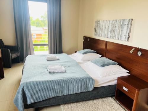 a bedroom with a bed with blue and white sheets at Villa Plena in Ośno Lubuskie