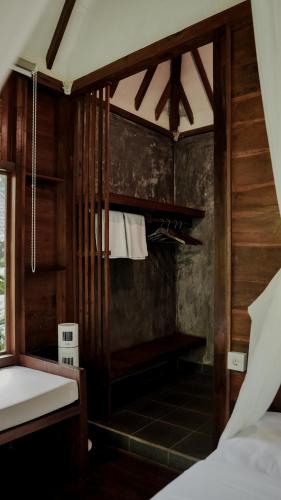 a room with a bedroom with a bed and atained at The Karu Cabin in Penebel