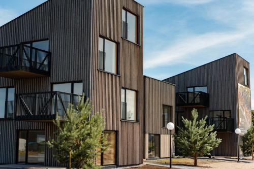 ein Apartmenthaus mit Holzfassade in der Unterkunft SVENCELE DUNES Marių g 31-1 in Svenele