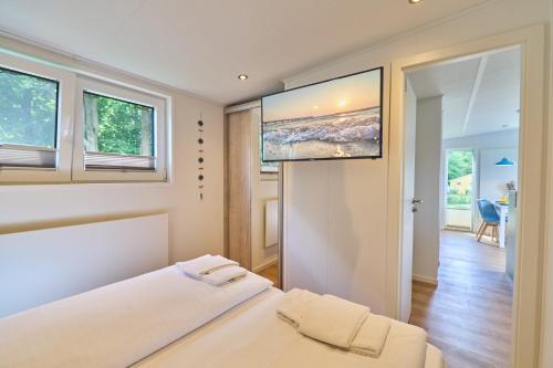 En eller flere senge i et værelse på Ostseecamp Ferienhaus Dünenglück