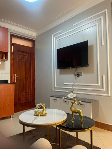 a living room with a table and a tv on a wall at Astro Motel in Nalakonge