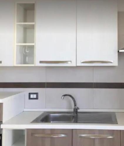 a kitchen with a sink and white cabinets at Palese Profumo di Mare in Santo Spirito