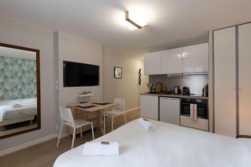 a bedroom with a bed and a kitchen with a desk at Appart'Hotel Tournusien in Tournus