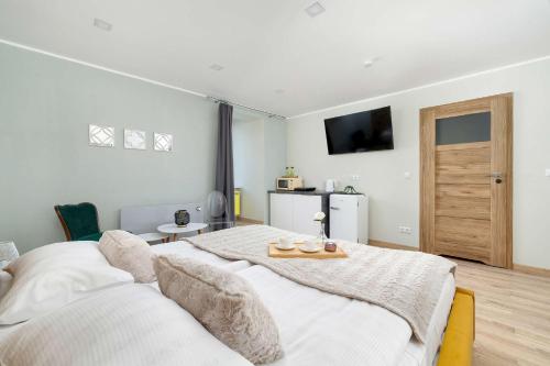 a bedroom with a large bed with a table on it at Komfortowe Studio w Centrum Bytomia Blisko Rynku by Noclegi Renters in Bytom
