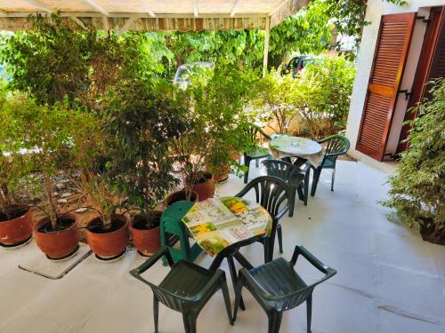 a patio with tables and chairs and potted plants at Akrata Golden Beach House in Aíyira