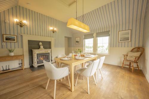 a dining room with a table and chairs and a fireplace at Laggandhu in Nethy Bridge