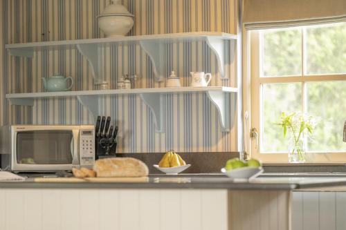a kitchen with a microwave and a counter with food on it at Laggandhu in Nethy Bridge