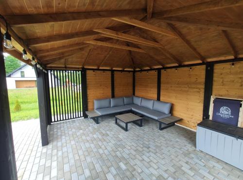 a patio with a couch and a table in a pavilion at Dwernikowe Wzgórze in Dwernik