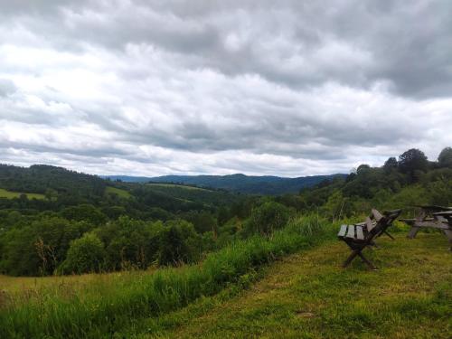 two benches sitting on top of a hill with a view at Dwernikowe Wzgórze in Dwernik
