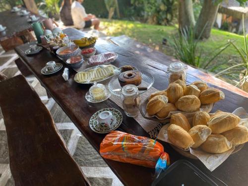 a picnic table with a bunch of pastries on it at Pousada Recanto dos Colibris in Guarapari