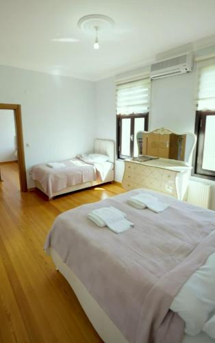 una stanza bianca con due letti e uno specchio di Peaceful Getaway Villa in Arsin ad Arsin