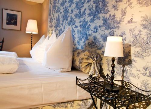 a bedroom with a bed with a blue and white wallpaper at Hotel Gasthof Post Nostalgie & Wohlfühlen in Kössen