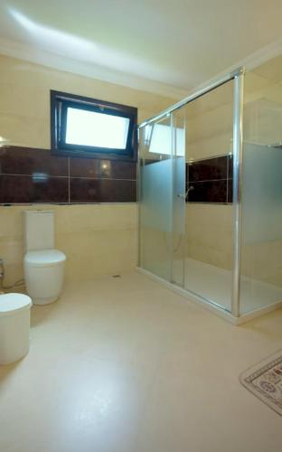 un bagno con wc e doccia in vetro di Peaceful Getaway Villa in Arsin ad Arsin