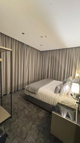 a bedroom with a bed in a room with curtains at فندق فيوري - المطار in Taif