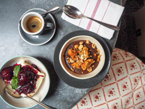 a table with two plates of food and a cup of coffee at Artist Residence London in London