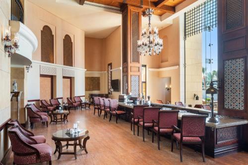 a restaurant with chairs and tables and a chandelier at Pickalbatros The Palace Port Ghalib in Port Ghalib