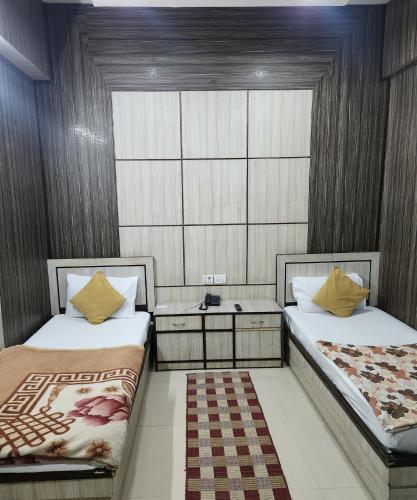 a room with two beds and a table in it at Hotel akash in Faridabad