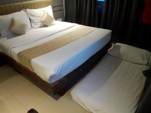 two beds in a hotel room with at J R Residency in Navi Mumbai