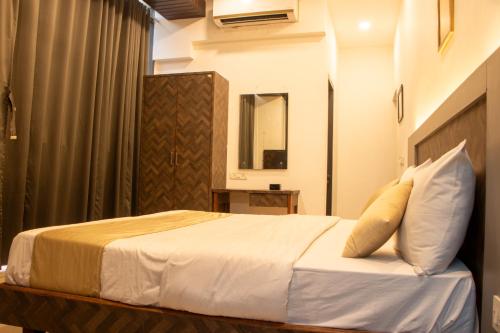 a hotel room with a bed and a mirror at J R Residency in Navi Mumbai