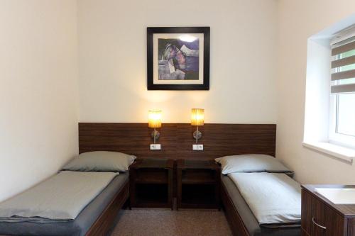 two beds in a room with lights on the wall at Vila Ruská - Ubytování u Teplic in Teplice