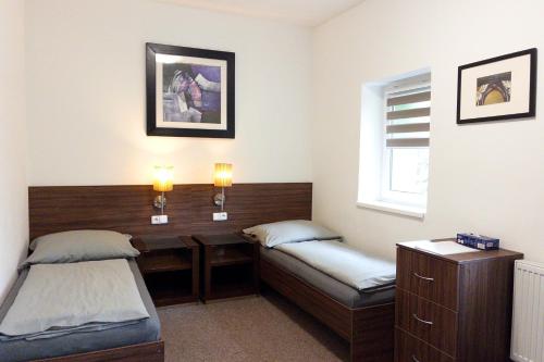 a room with two beds and a bench and a window at Vila Ruská - Ubytování u Teplic in Teplice