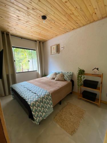 a bedroom with a bed with a wooden ceiling at Raízes da Serra , Refúgio Beira-Rio no Baixo Sana in Córrego da Luz