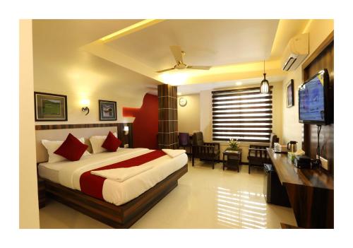 a hotel room with a bed and a television at Hotel Kochi Caprice in Cochin