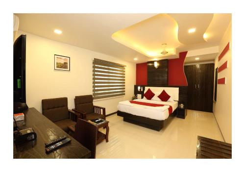a bedroom with a bed and a living room at Hotel Kochi Caprice in Cochin