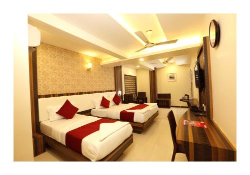 a hotel room with two beds and a chair at Hotel Kochi Caprice in Cochin