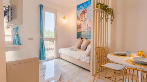 a small room with a bed and a table and a window at Suite Sirmione Studio - Italian Homing in Sirmione